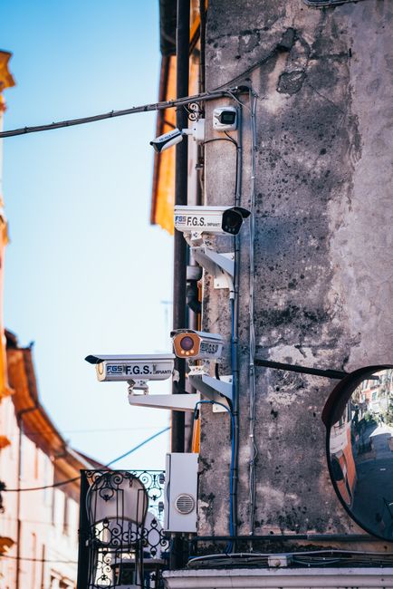 Close-up view of CCTV cameras mounted on a building wall in a city street.